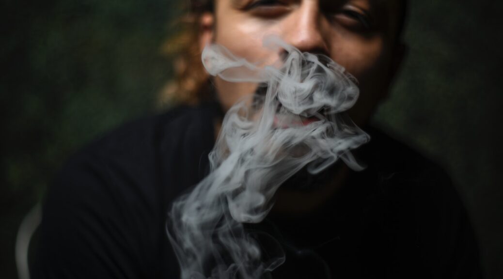A man with smoke in front of his face