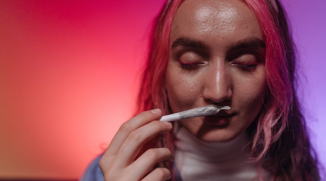 a woman taking a deep whiff of her weed joint